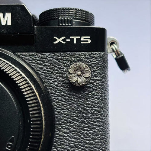 Close-up of a sakura design flash pc sync terminal cap cover for olympus om camera