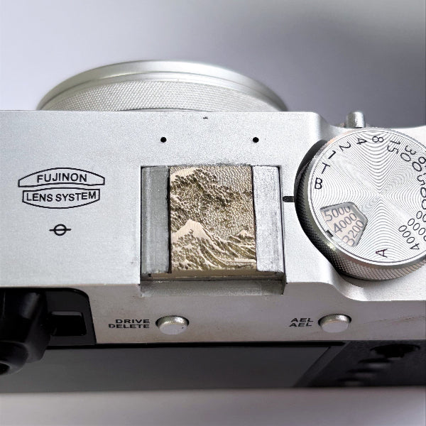 Close-up of a camera white brass hot shoe cover detail in sea wave