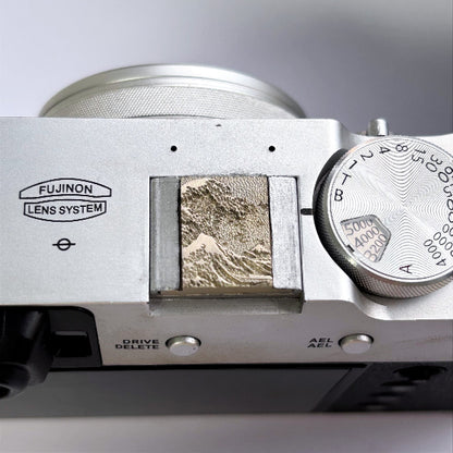 Close-up of a camera white brass hot shoe cover detail in sea wave