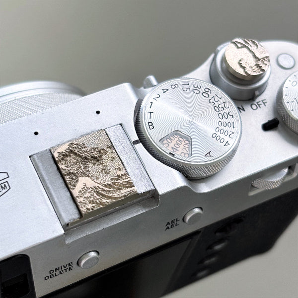 Close-up of a camera sea wave hot shoe cover and shutter release