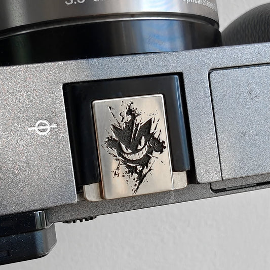 white copper gengar hot shoe cover on digital camera