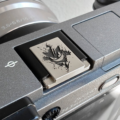 Close-up of a silver Pokémon Gengar engraved hot shoe cover on mirrorleass camera