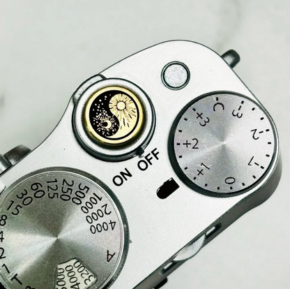 brass or copper camera accessory with celestial motif